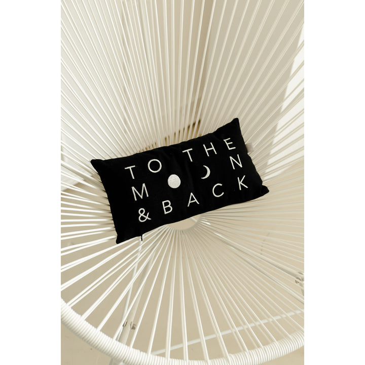 coussin noir to the moon and back sur chaise blanche 4avril