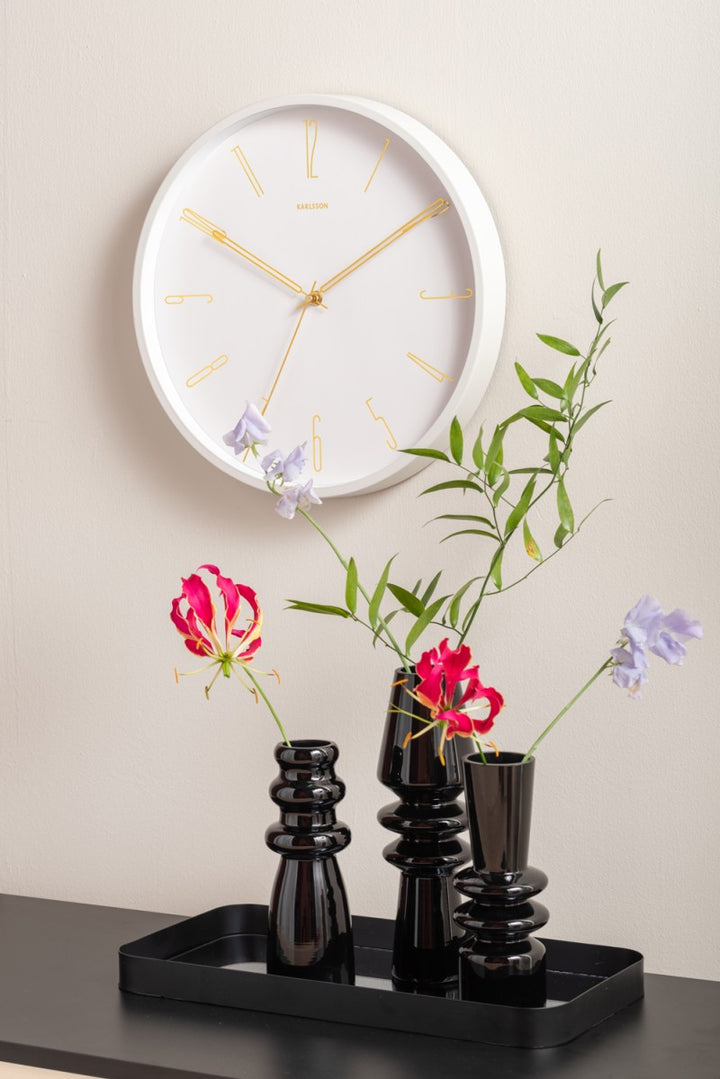 3 vases en verre noir avec fleurs et horloge au mur 4avril